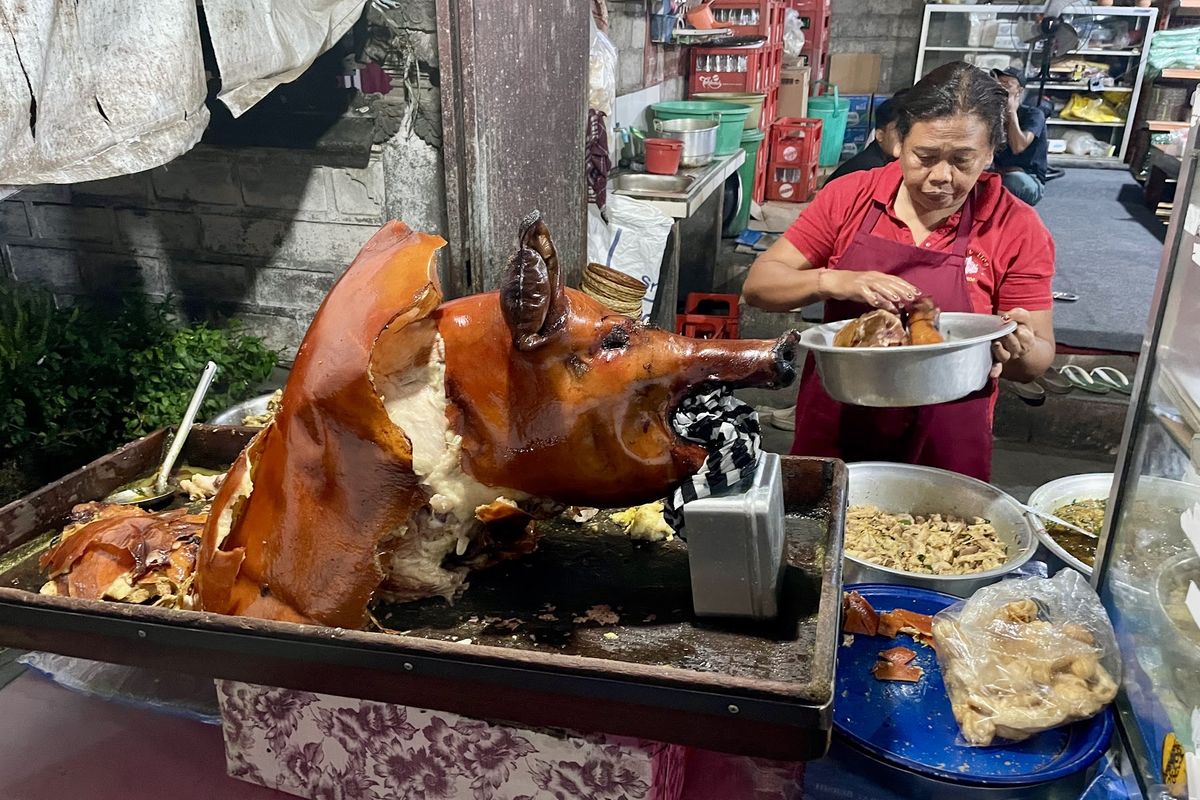 A whole roast pig being carved at the counter of Babi Guling Pande Bangli in Bangli, Bali