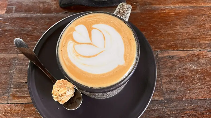 A coffee with latte art and an iced matcha at Chela, an open-air cafe in Bingin