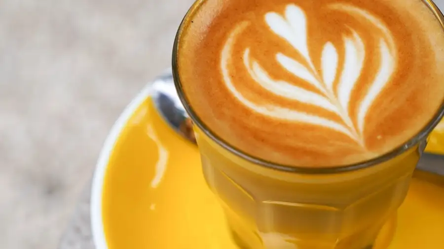 A coffee in a glass on a yellow saucer at Milk & Madu Uluwatu