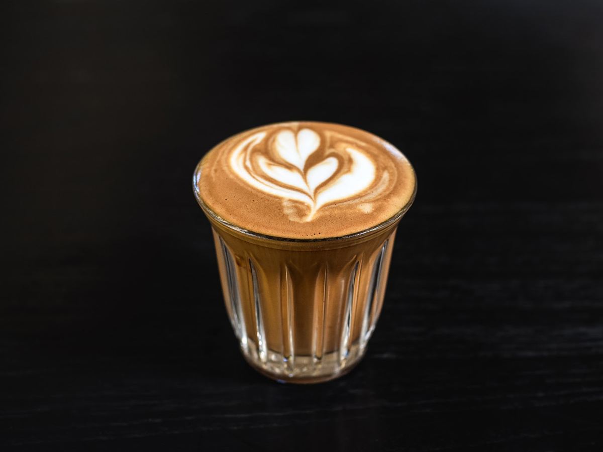 A coffee with latte art in a small glass at UM Brunch & Specialty Coffee in Uluwatu, Bali
